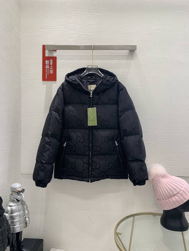 Gucci Fw新款双g满logo黑色连帽羽绒服 这款拉链羽绒服是焕新推出的配饰和成衣系列中的一款 再生尼龙由可回收利用的缝纫线和辅料制成，依托灰色背景突显品牌